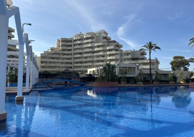 Piscina principal con arcos y puente en Benal Beach Hub